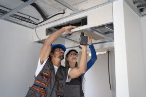 two plumbers are maintaining the modern building air conditioning system